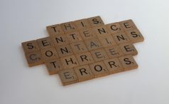 Scrabble letters arranged into the sentence: This Sentence Contains Threee Erors