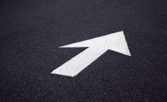 Painted white direction arrow on tarmac