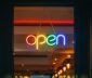 Illumiated multi-color neon open sign in store window 