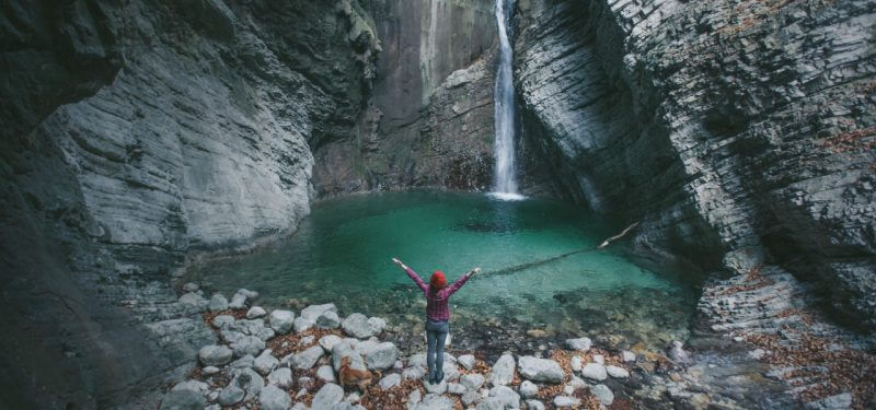 Woman standing in front of a waterfall