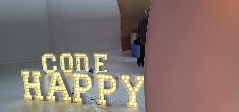 A set of illuminated letters spelling out Code Happy