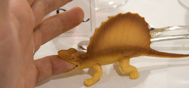 Dinosaur toy biting a finger