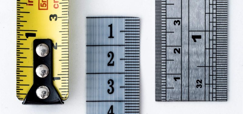 Yellow measuring tape and rulers on white background