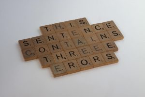 Scrabble letters arranged into the sentence: This Sentence Contains Threee Erors