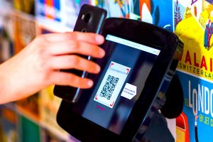 A QR code being scanned by a smartphone-wielding user