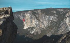 Man in red t-shirt walking a highline at Taft Point, Yosemite.