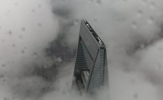 Ariel photograph of high rise building pushing through clouds