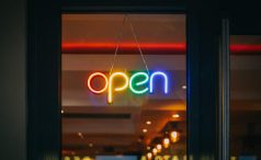Illumiated multi-color neon open sign in store window 