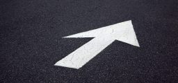 Painted white direction arrow on tarmac