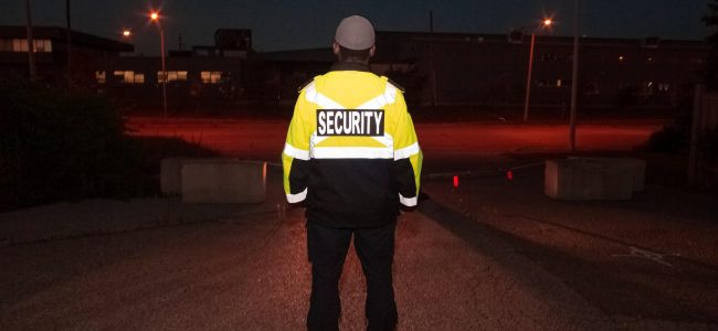 Security guard in yellow and black jacket on street