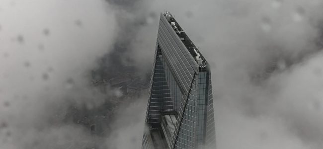 Ariel photograph of high rise building pushing through clouds