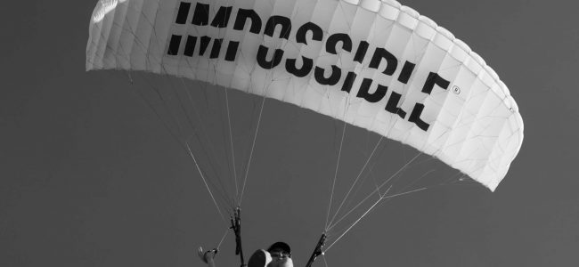 White parachute with impossible written in black upon the canopy