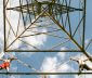 Power line tower with two men climbing it