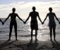 People holding hands on a beach
